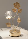 Golden metal leaf sculpture tabletop ornament features a crystal ball.